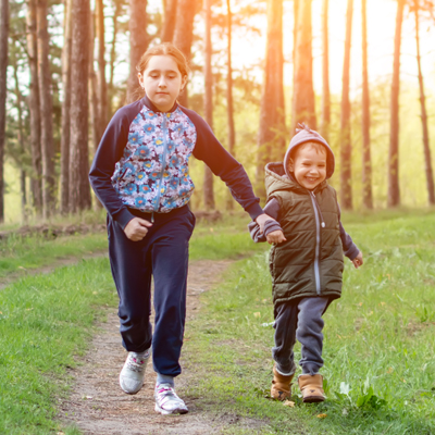 children in the forest, boy and girl run through the forest, play in nature, entertaining walk in the park